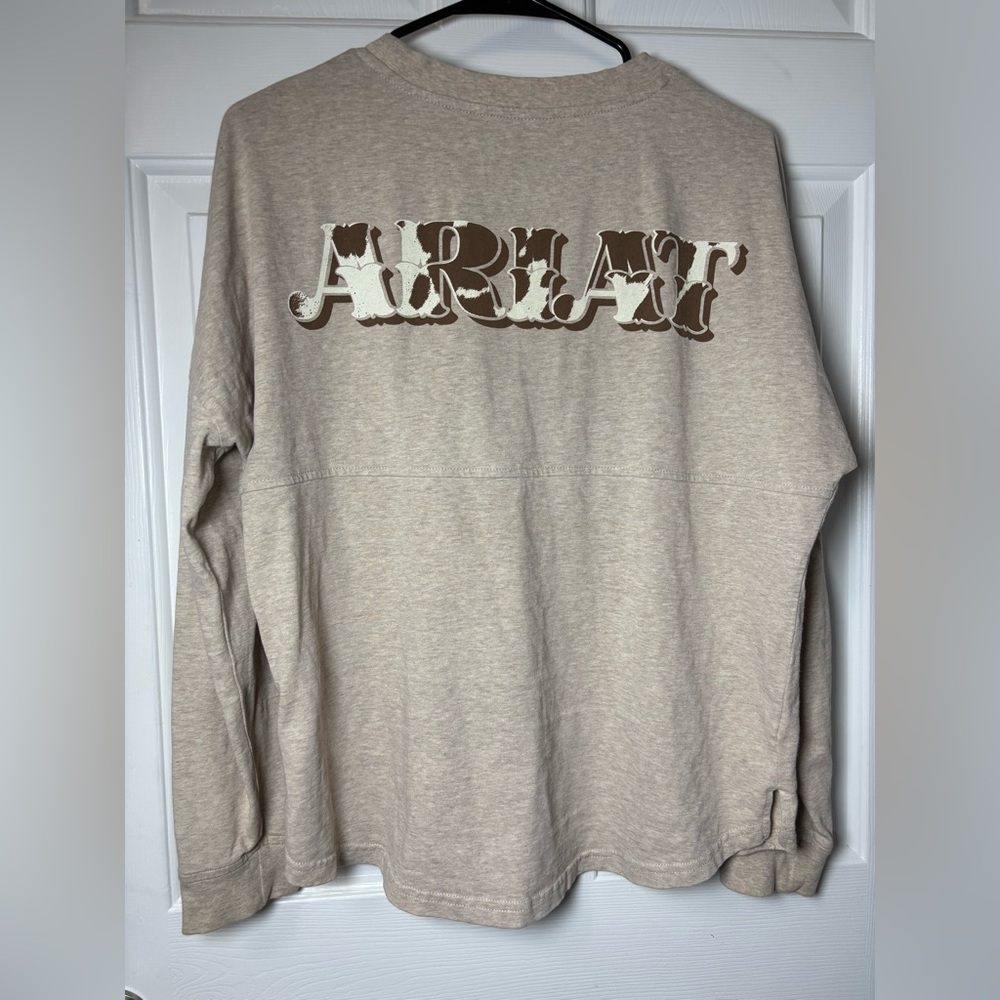 Small ARIAT" graphic on the back cowhide-patterned fill and a drop-shadow effect